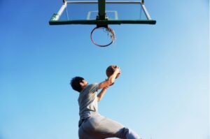 basketball player jumping to score a point in the hoop