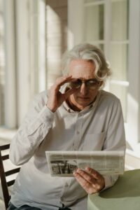 senior looking at stocks in newspaper