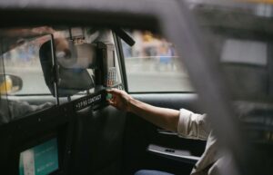 taxi passenger in backseat using credit card machine to make a payment