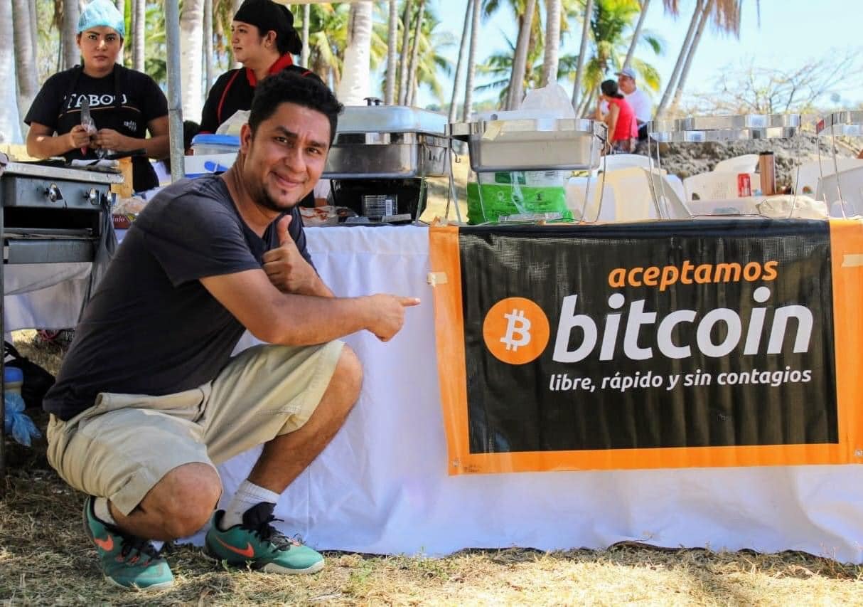 El Salvador person pointing to bitcoin banner for decentral publishing