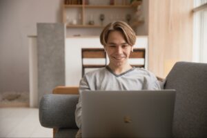 crypto backed lending person smiling in front of a laptop for decentral publishing