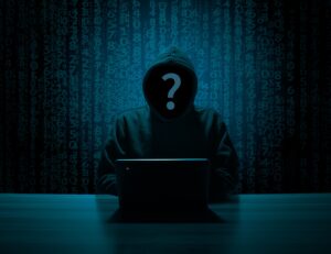 crypto unknown man in hoodie in front of a laptop with a matrix style dark background for decentral publishing