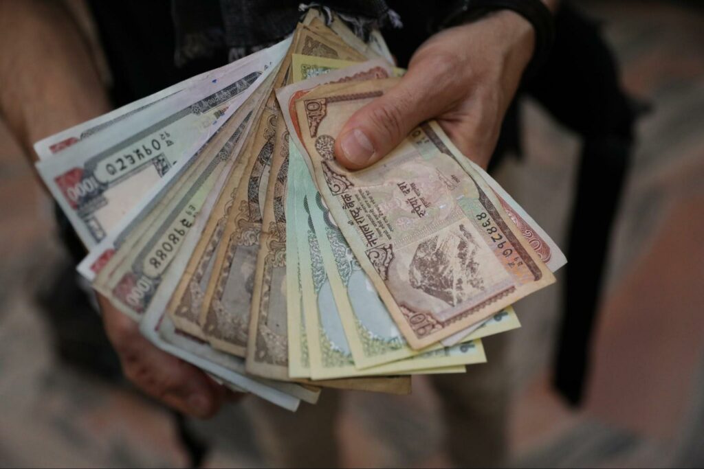 native currencies person holding large stack of money in their native currency for decentral publishing