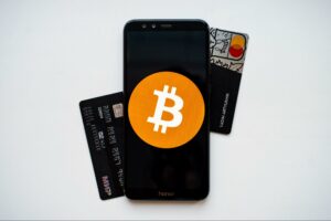 secure crypto investments smart phone with the bitcoin logo on it and a credit card on the side for decentral publishing