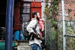 sovereign man holding child with a backpack and self defence weapon decentral publishing