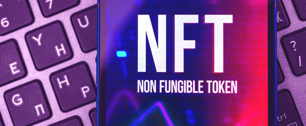 nft non fungible tokens on phone screen over purple and red keyboard decentral publishing