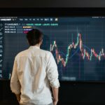 trader studying large screen with forex trading chart